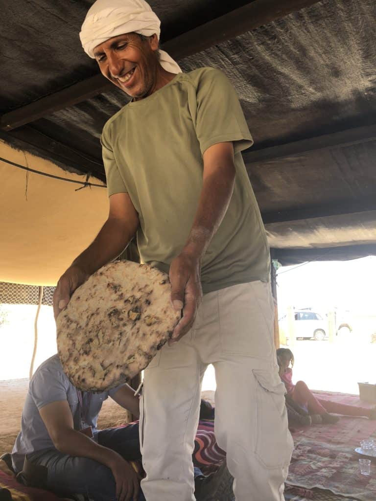 Man holding bread in tent in Negev, Israel